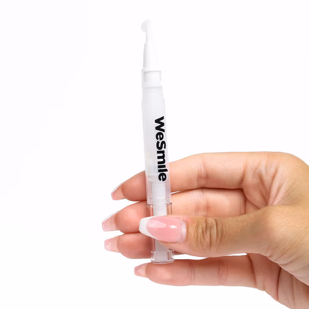 En hånd, der holder en WeSmile-gelpen